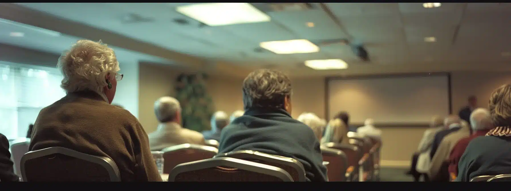 a focused caregiver training session in a well-equipped conference room, featuring attentive participants engaged in a lively discussion about resources for caring for individuals with dementia, illuminated by sharp overhead lighting that enhances the professional atmosphere. a focused caregiver training session in a well-equipped conference room, featuring attentive participants engaged in a lively discussion about resources for caring for individuals with dementia, illuminated by sharp overhead lighting that enhances the professional atmosphere.