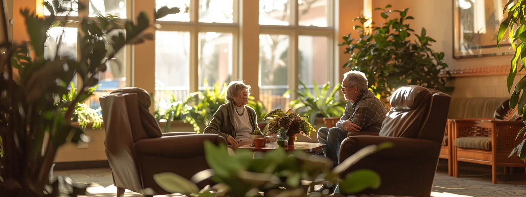 a serene and warm interior of an assisted living facility, showcasing a cozy sitting area with soft lighting and inviting decor, where an older couple shares a moment of connection while surrounded by plants and gentle reminders of home.