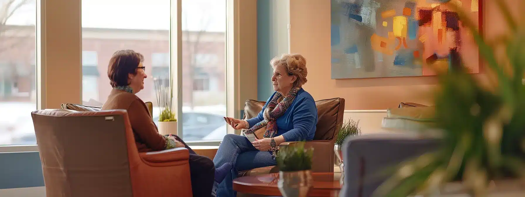 a warm, inviting office setting featuring a compassionate caregiver engaged in a supportive conversation with an elderly individual, emphasizing accessible dementia care options in a modern michigan facility.